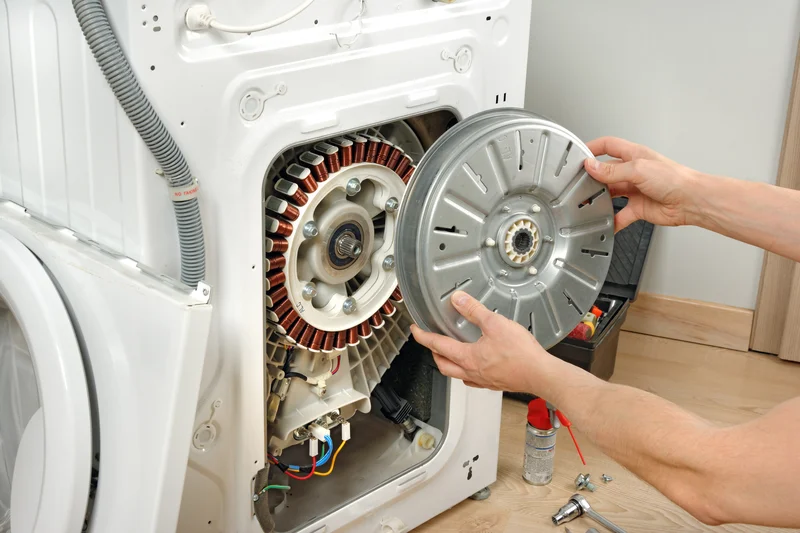 Appliance technician repairing the direct drive motor of a washing machine
