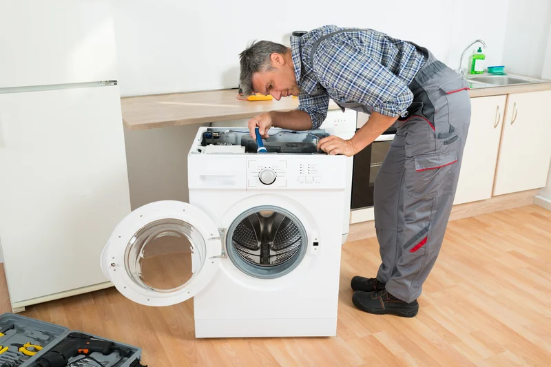 Professional technician repairing front-load washing machine. Professional technician repairing front-load washing machine.
