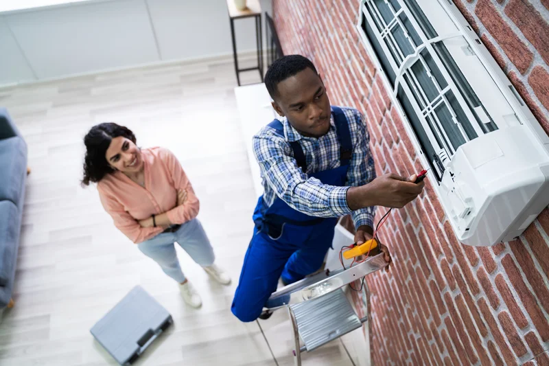 AC repair technician fixing ductless mini split wall unit AC repair technician fixing ductless mini split wall unit