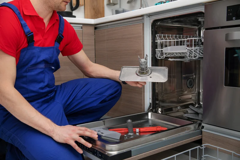 Dishwasher repair technician servicing home kitchen appliance Dishwasher repair technician servicing home kitchen appliance